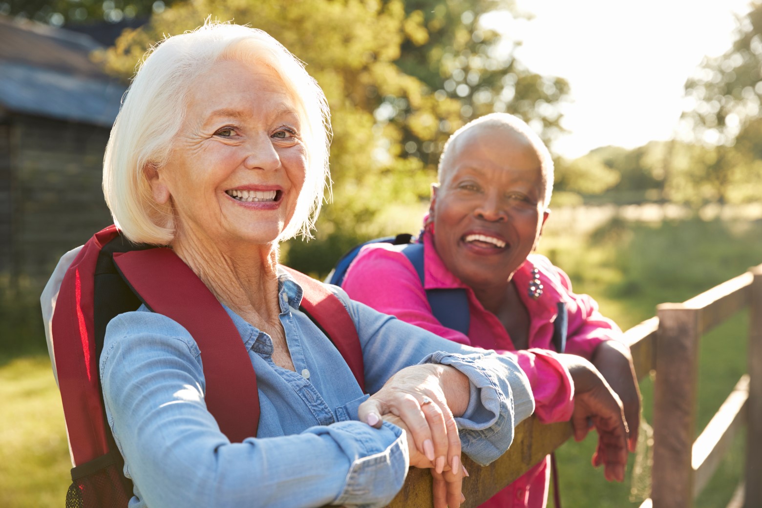 Two smiling women sitting in the sun