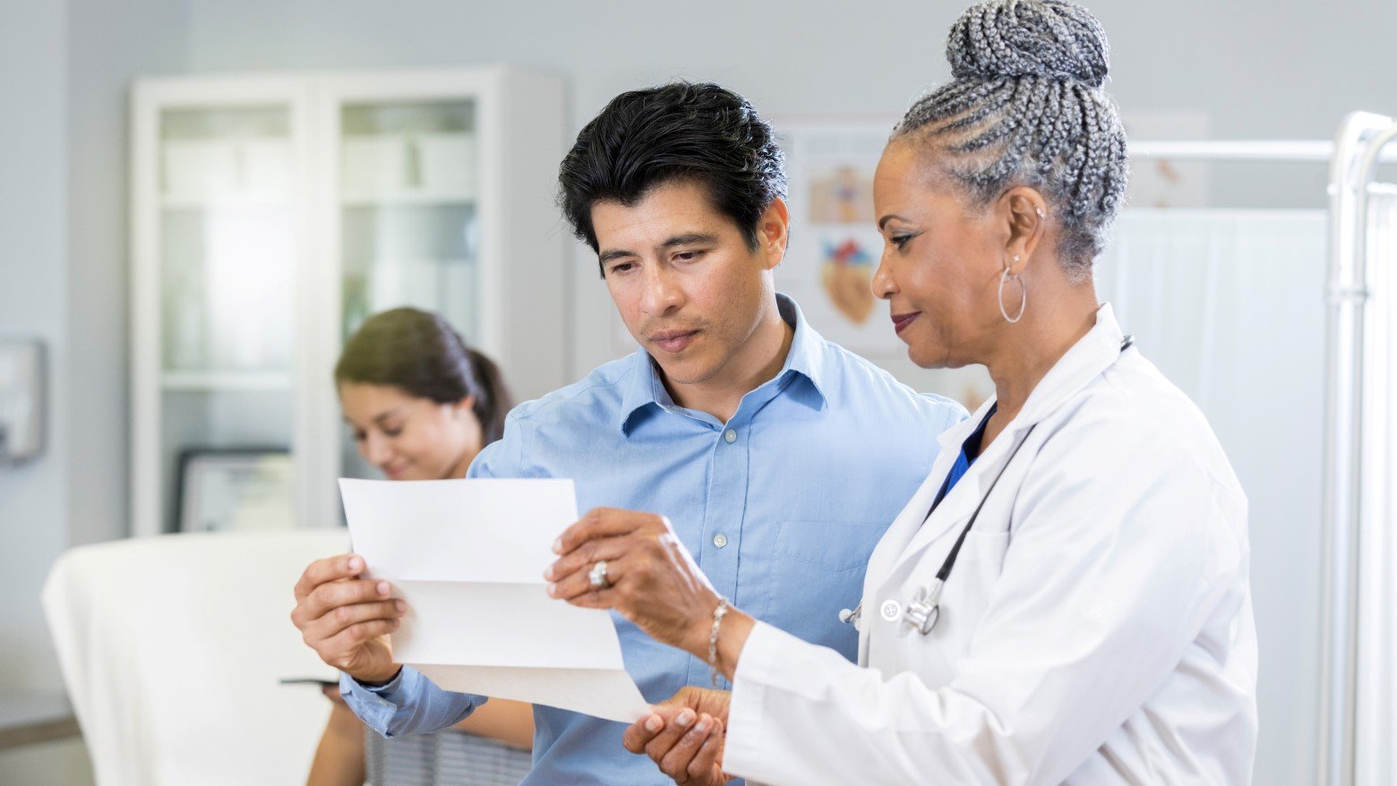 doctor showing a patient a piece of paper