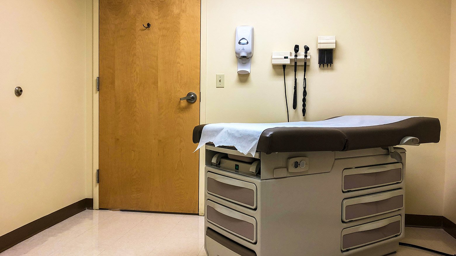 A doctor's examination room with an examination table and equipment