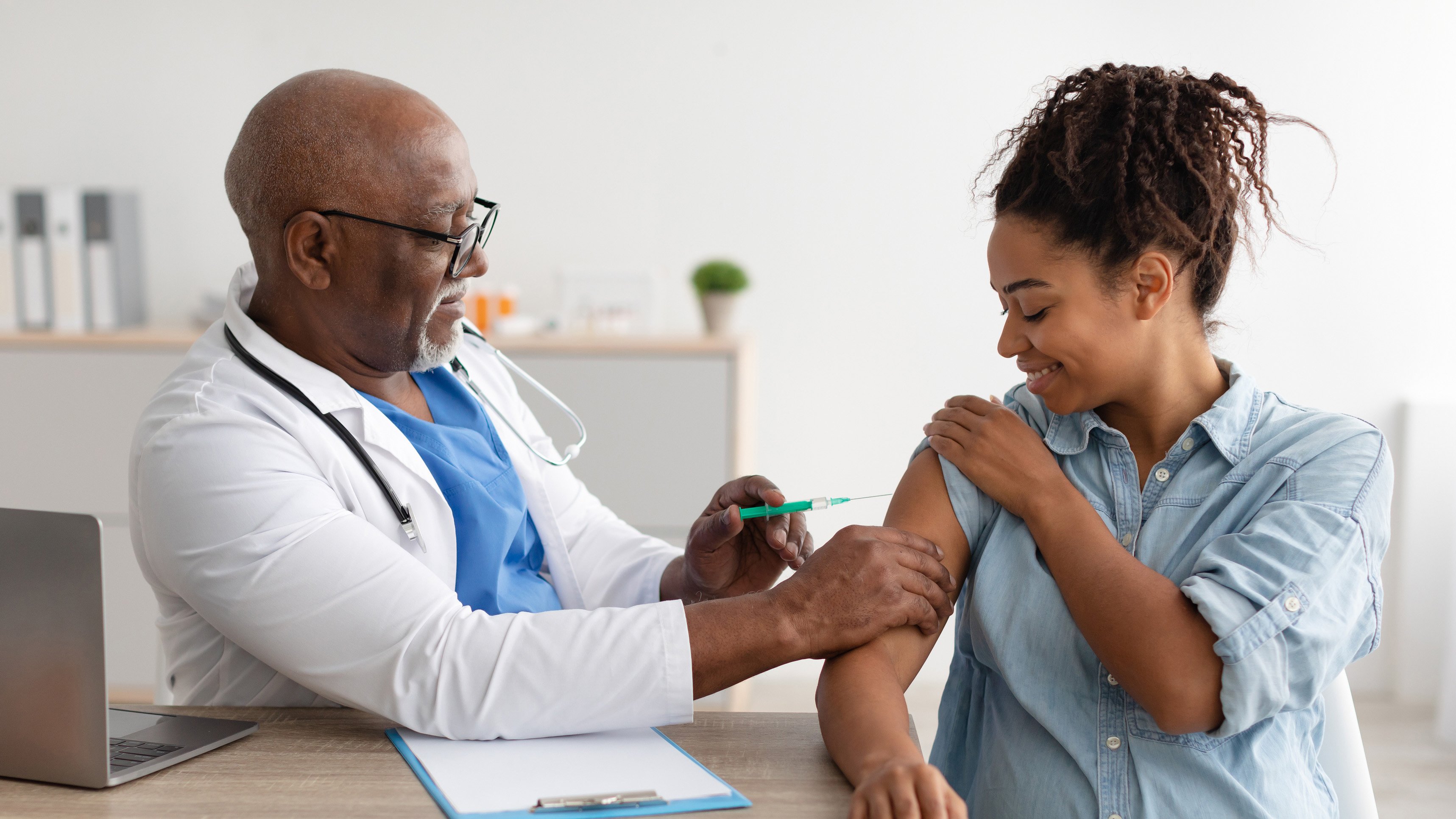 doctor giving pregnant patient vaccine