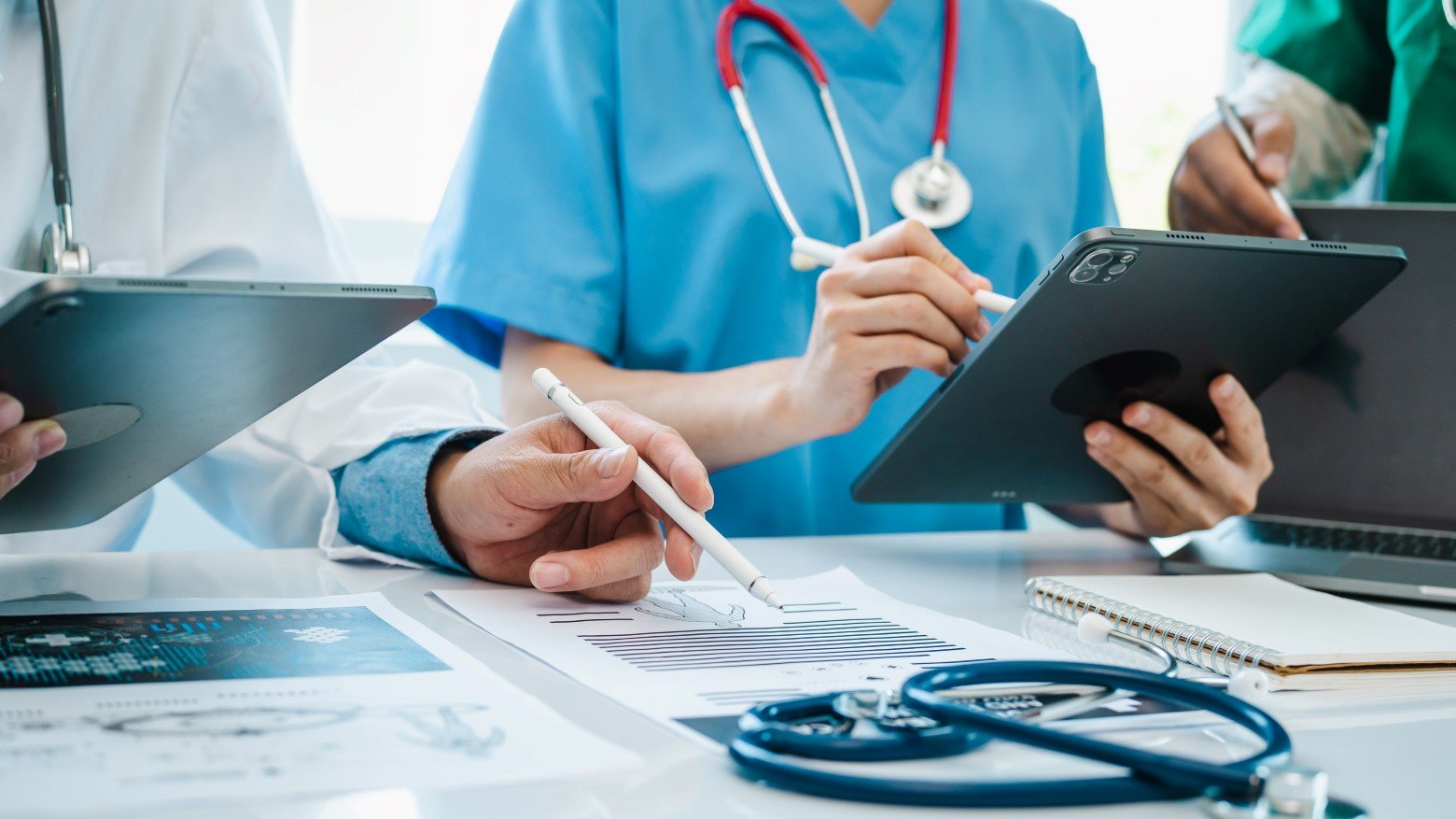 doctors using tablets and doing paperwork