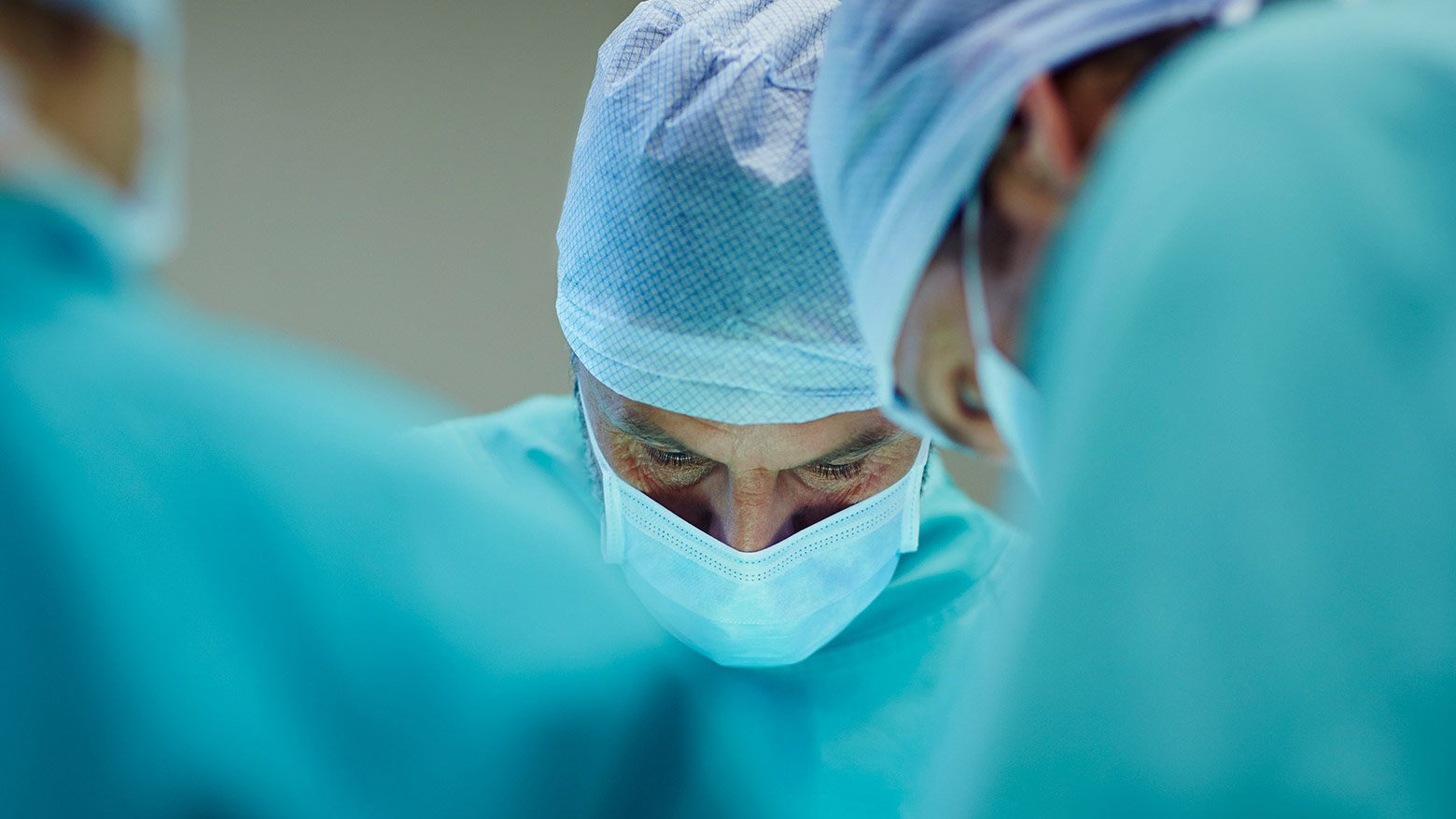 A team of doctors wearing surgical scrubs and masks