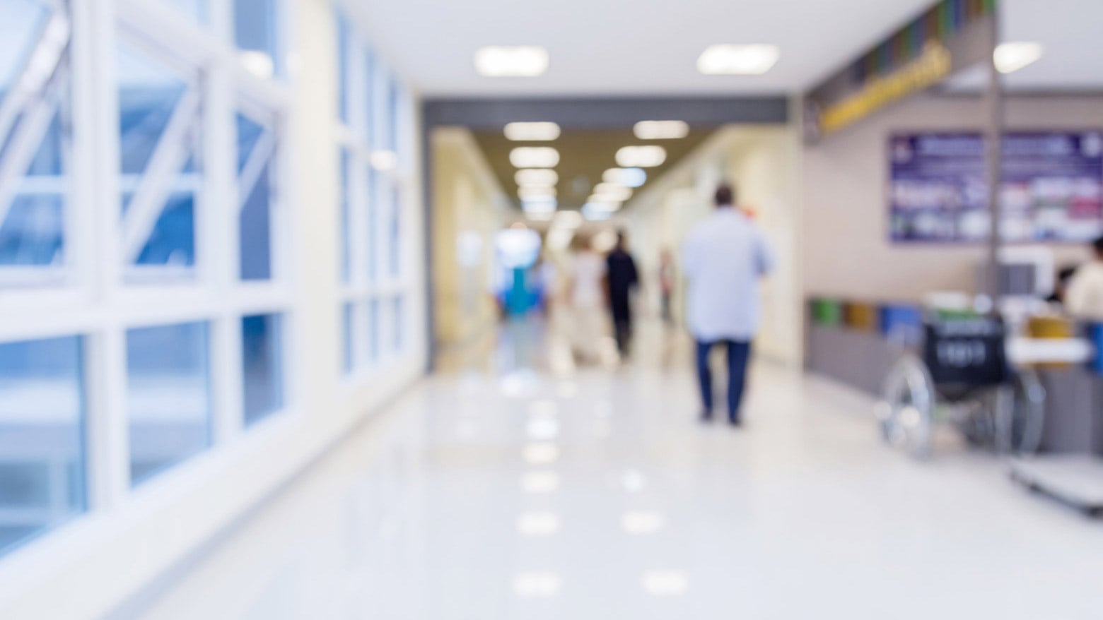 People walk through a hospital hallway