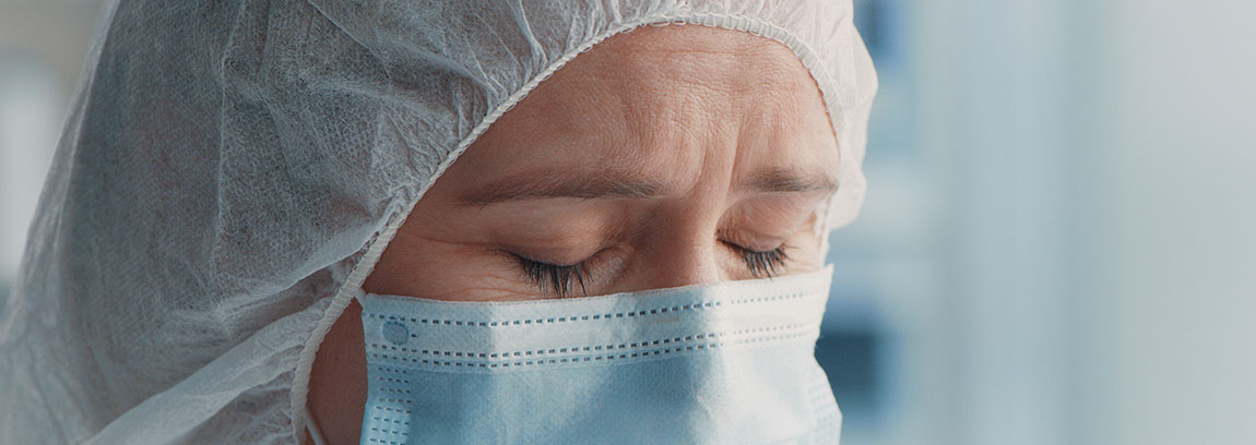 Woman wearing medical mask with her eyes closed