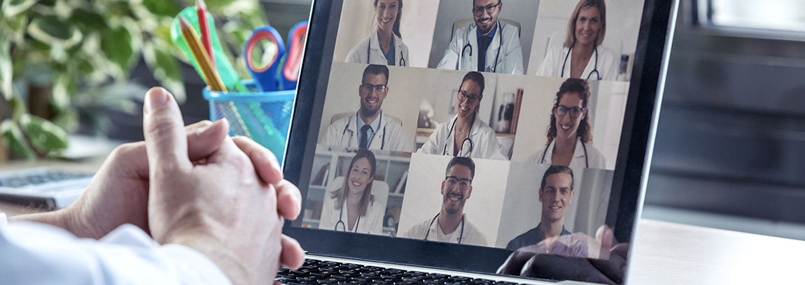 Doctors has a virtual call on a tablet with several other doctors