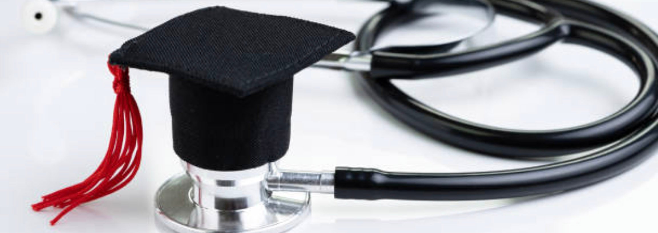 A miniatures graduation cap sits atop a doctor's stethoscope.
