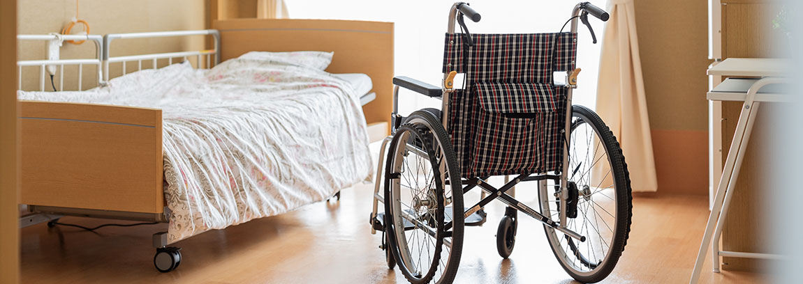 A wheelchair in a room with a medical bed
