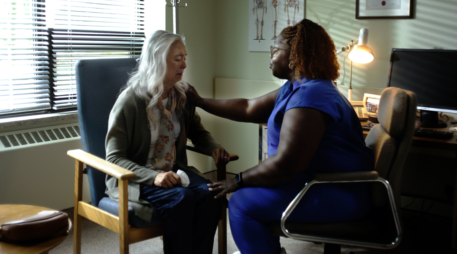 A physician sitting with an elderly patient