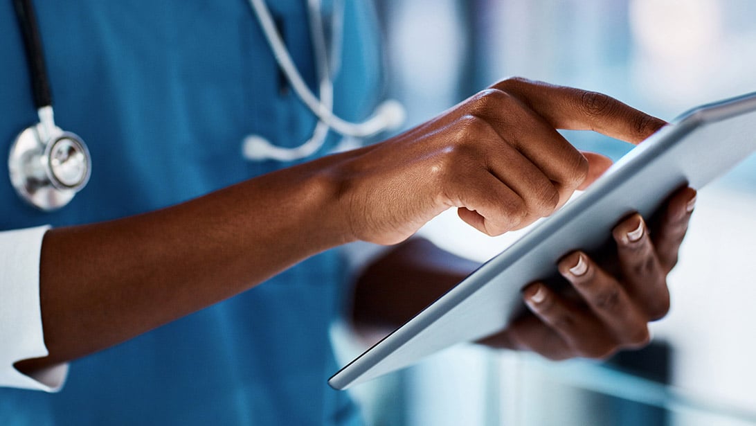 A doctor operates a tablet computer.
