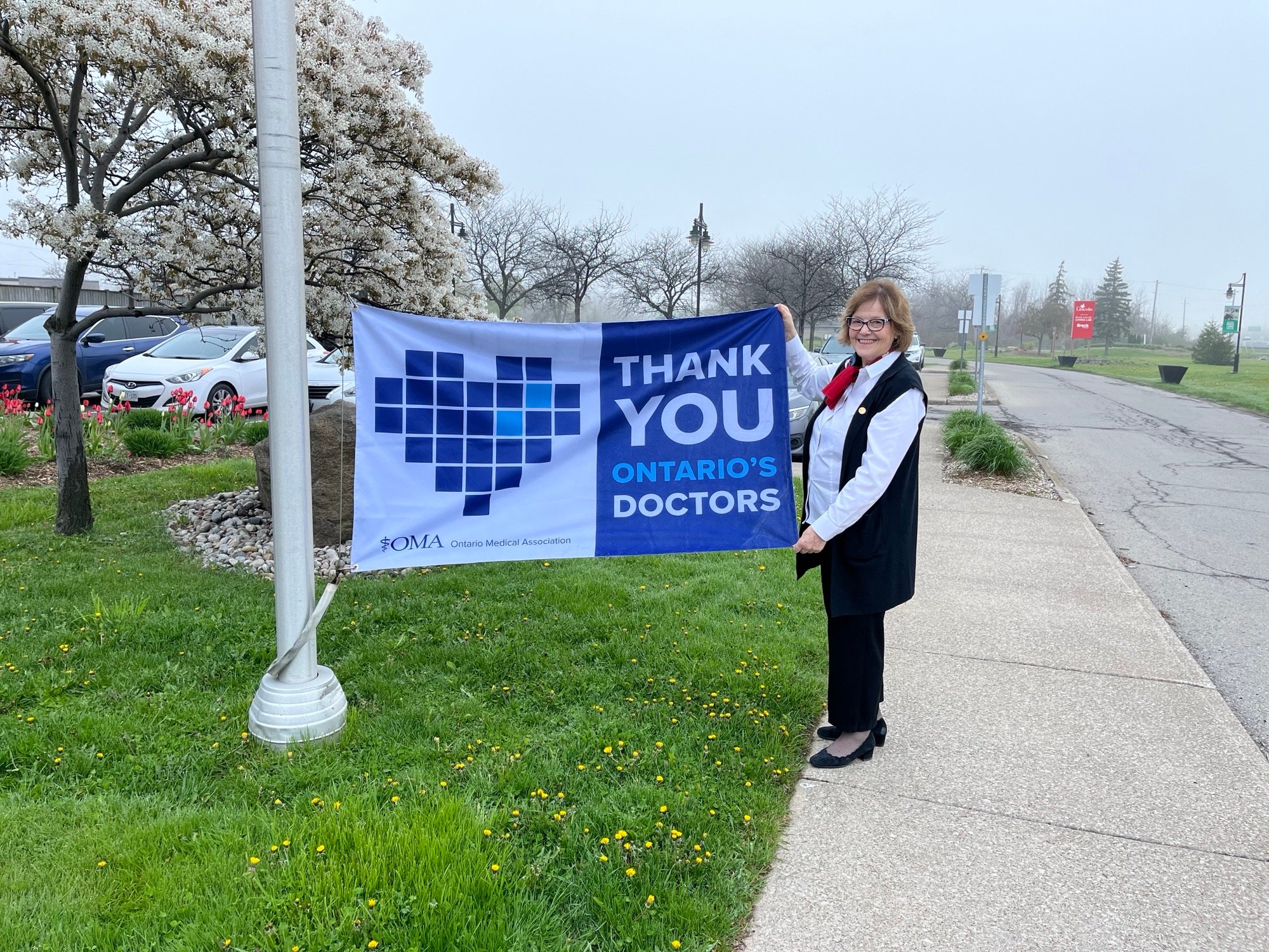 Lincoln Mayor Sandra Easton holds a flag that says Thank You Ontario's Doctors