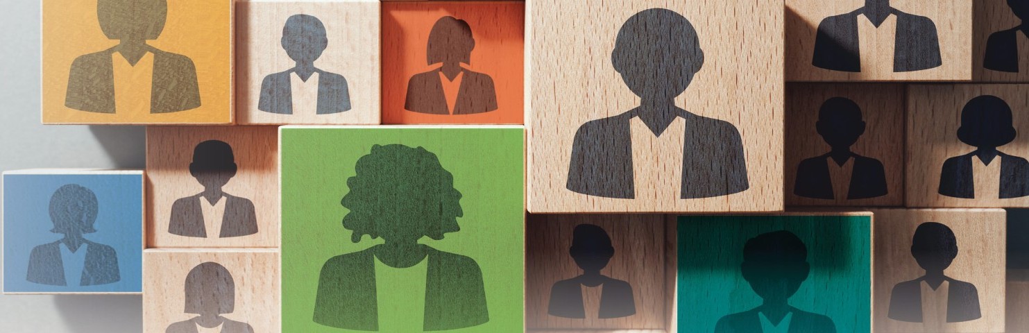 Wooden blocks of different colours are stacked and feature silhouettes of different types of people.