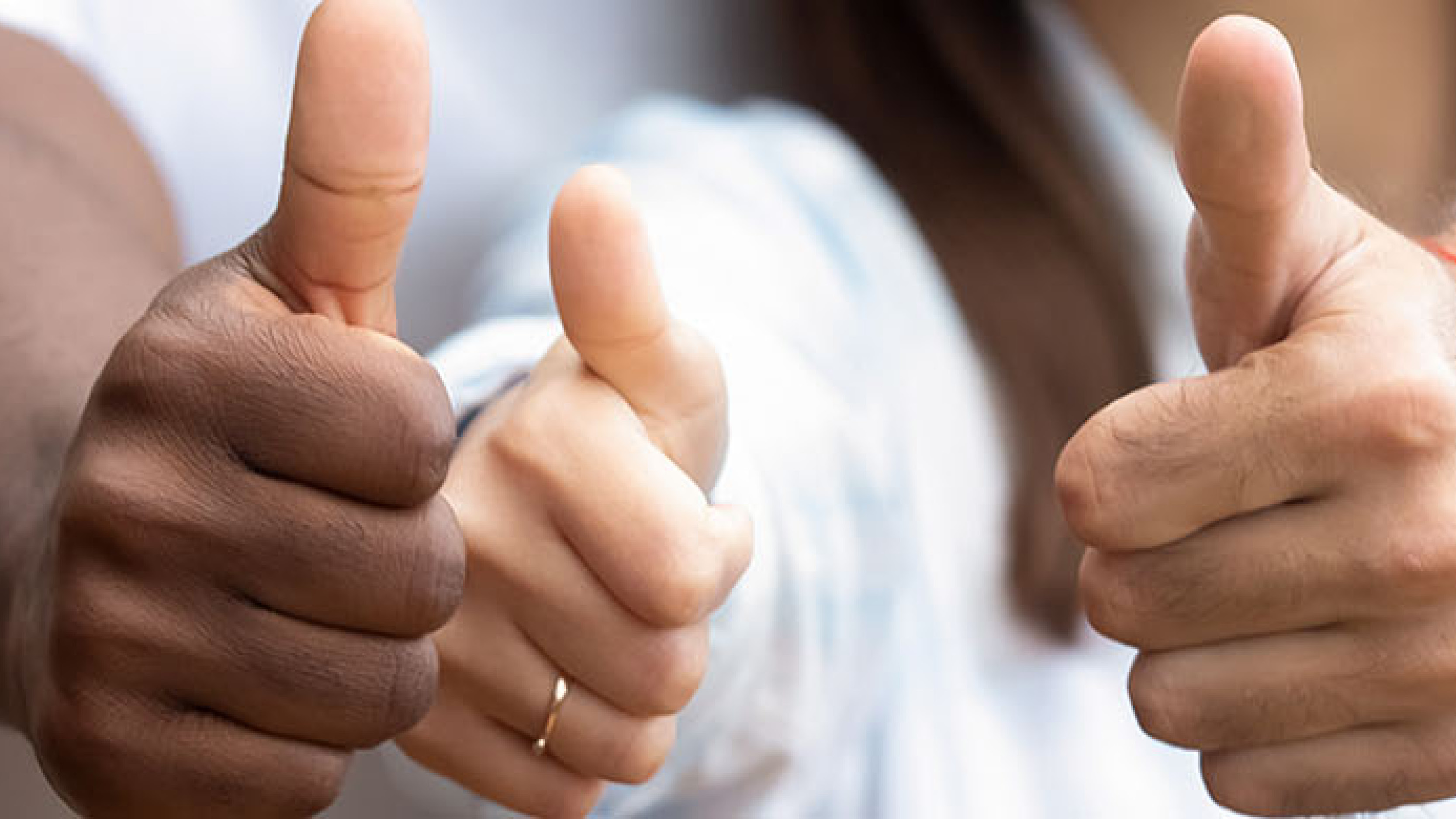 Three physicians signling thumbs up 