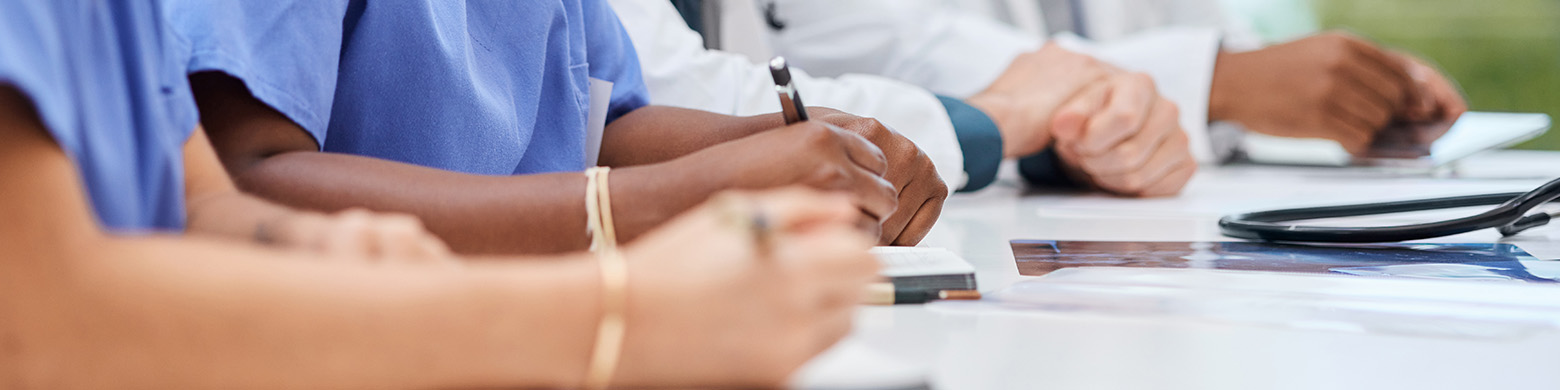 Medical professionals are seen sitting around a table.
