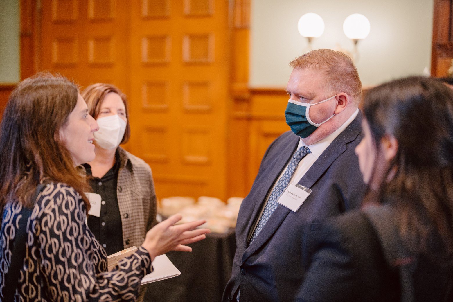 Man in a mask having a conversation with three women