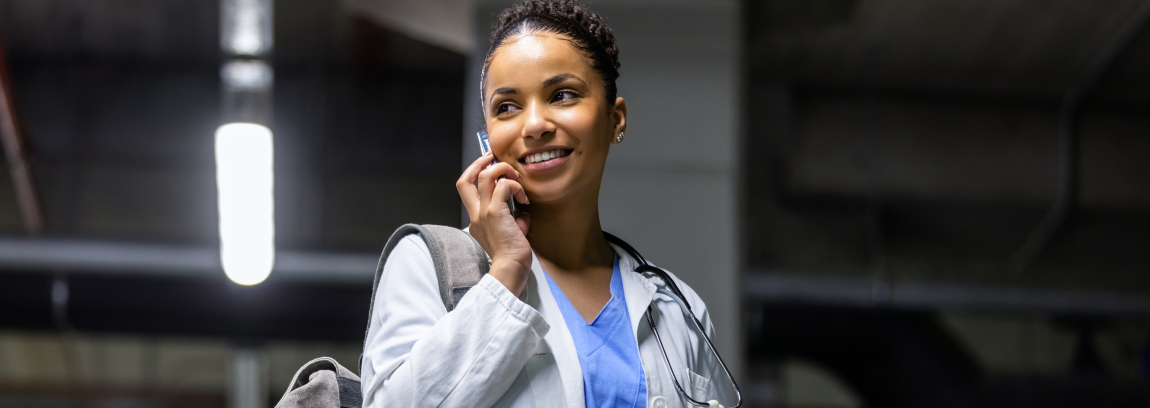 A physician looks to the side while talking on her cellphone